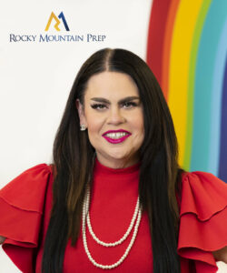 Tricia Noyola smiles into the camera in front of a background that reads "Rocky Mountain Prep."