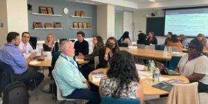 SAQ Fellows sit at round tables for small group discussions.